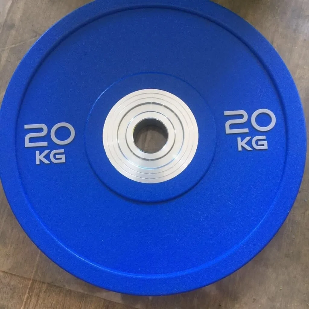 A shiny, urethane-coated weight plate next to a classic cast iron plate