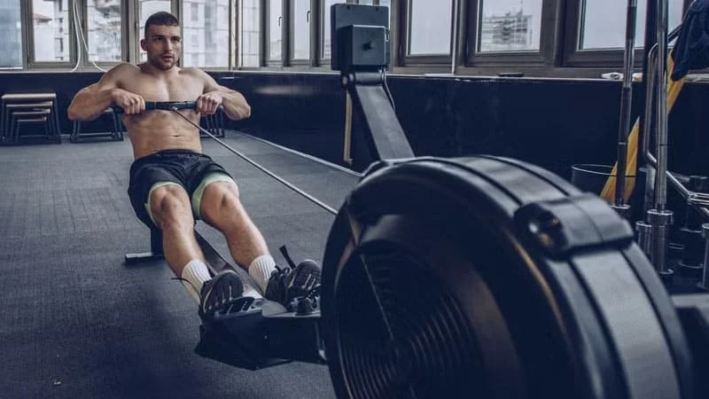 A person working out intensely on a rowing machine