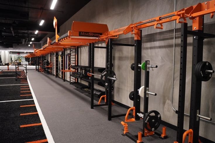 A modern gym with a striking color scheme of grey and orange accents