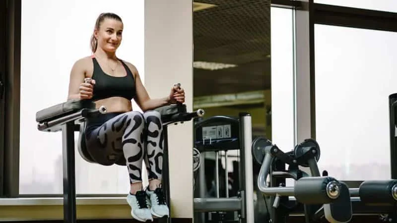 A person using a Captain's Chair for leg raises in a gym
